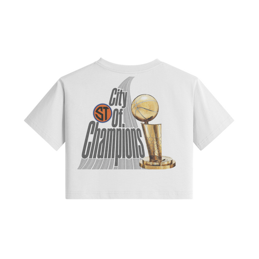 A white short-sleeve crop top t-shirt featuring a graphic print of the San Antonio Spurs championship trophy and the text 'City of Champions' on the front, set against a plain white background.